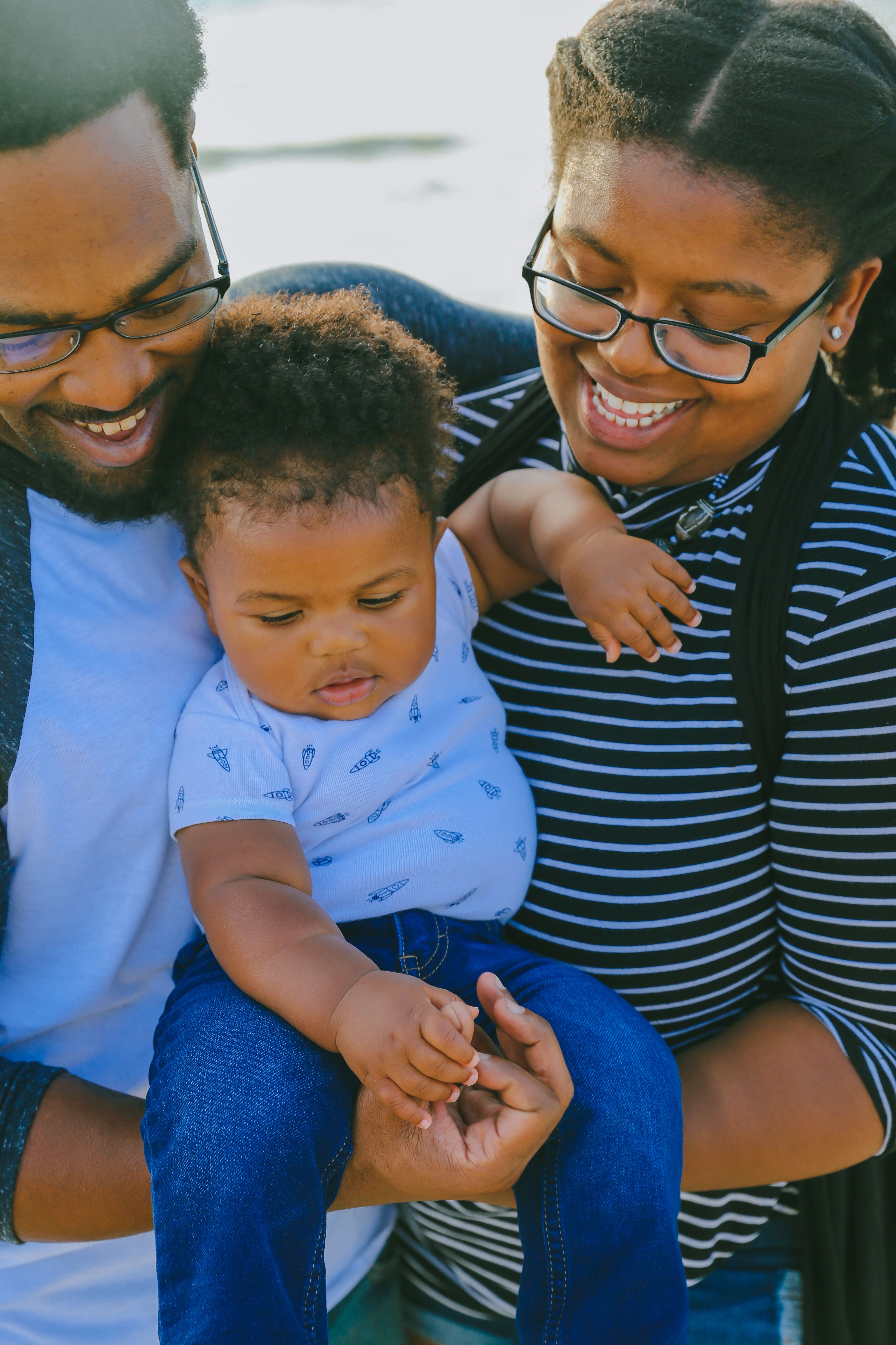 A smiling Black family with their baby